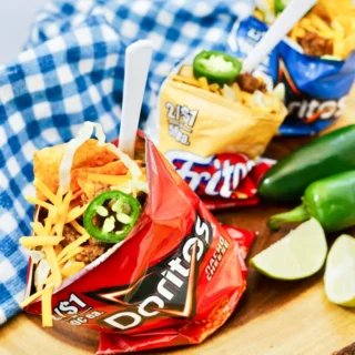 Close up view of walking taco showing layers of chips, seasoned beef, cheese and toppings