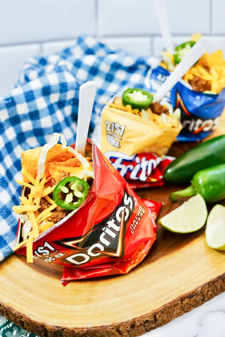 Close up view of walking taco showing layers of chips, seasoned beef, cheese and toppings