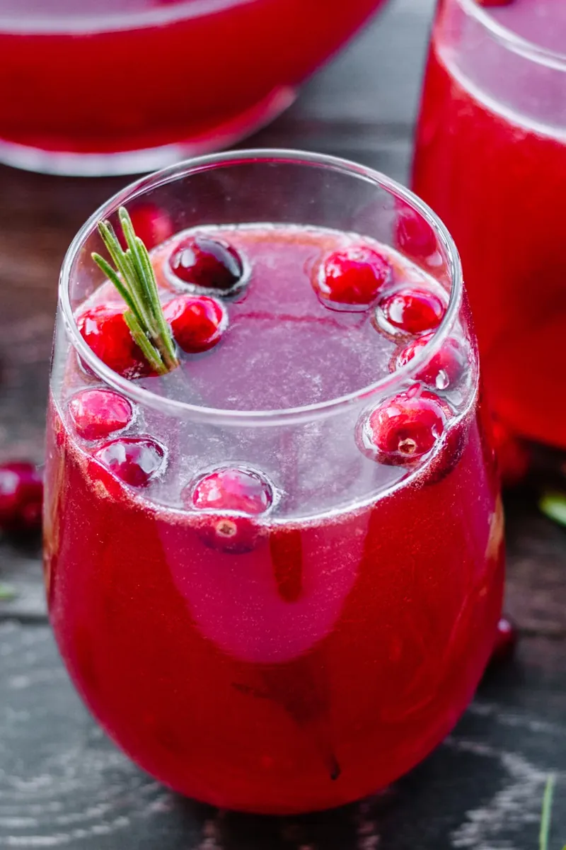 Sparkling cranberry holiday punch with floating cranberries and rosemary sprig