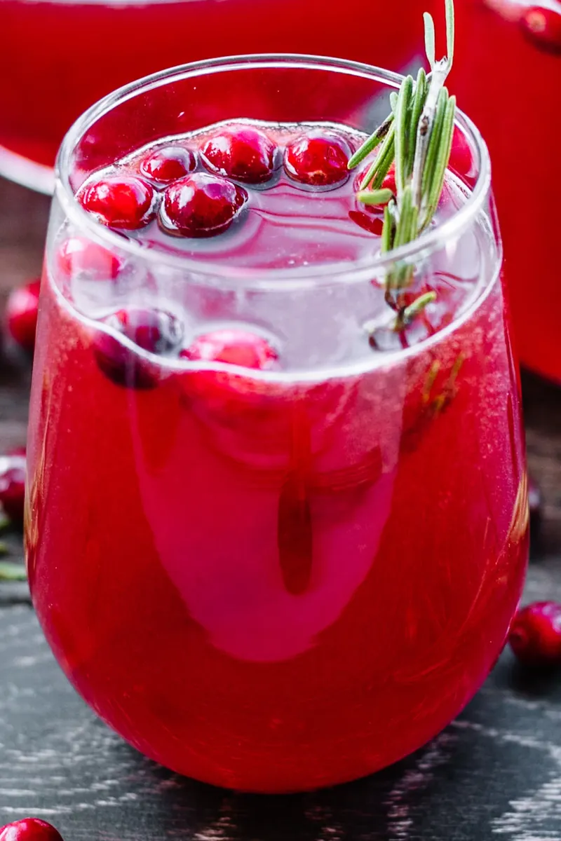 Overhead view of cranberry holiday punch with floating cranberries and rosemary garnish