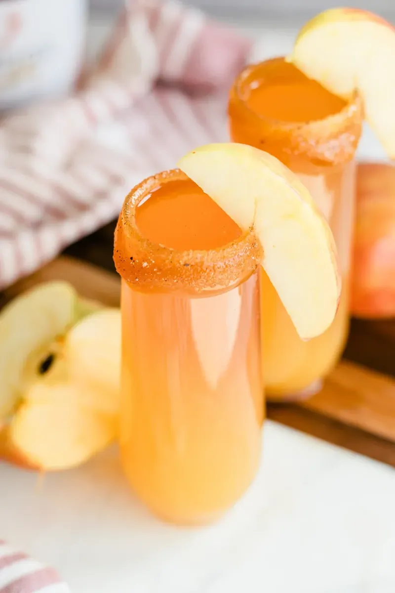 Completed apple cider mimosa with caramel rim and apple garnish ready to serve