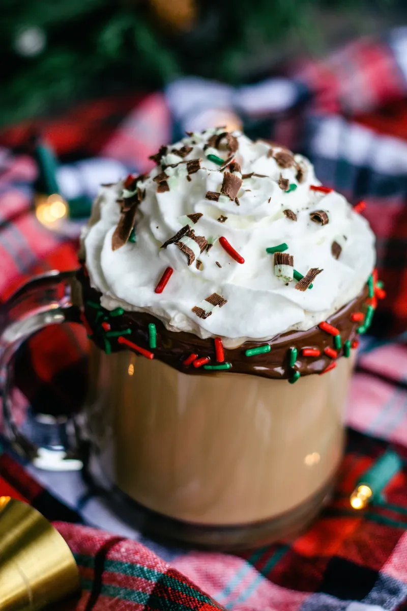 Boozy Christmas coffee on plaid fabric with holiday decorations