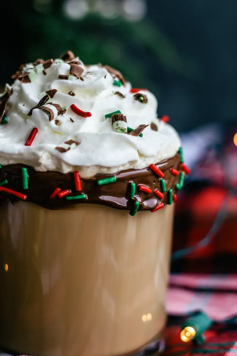 Christmas coffee cocktail topped with whipped cream and holiday sprinkles