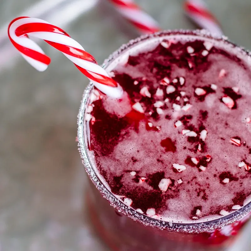 Close-up detail of candy cane margarita showing sugar rim and candy cane garnish