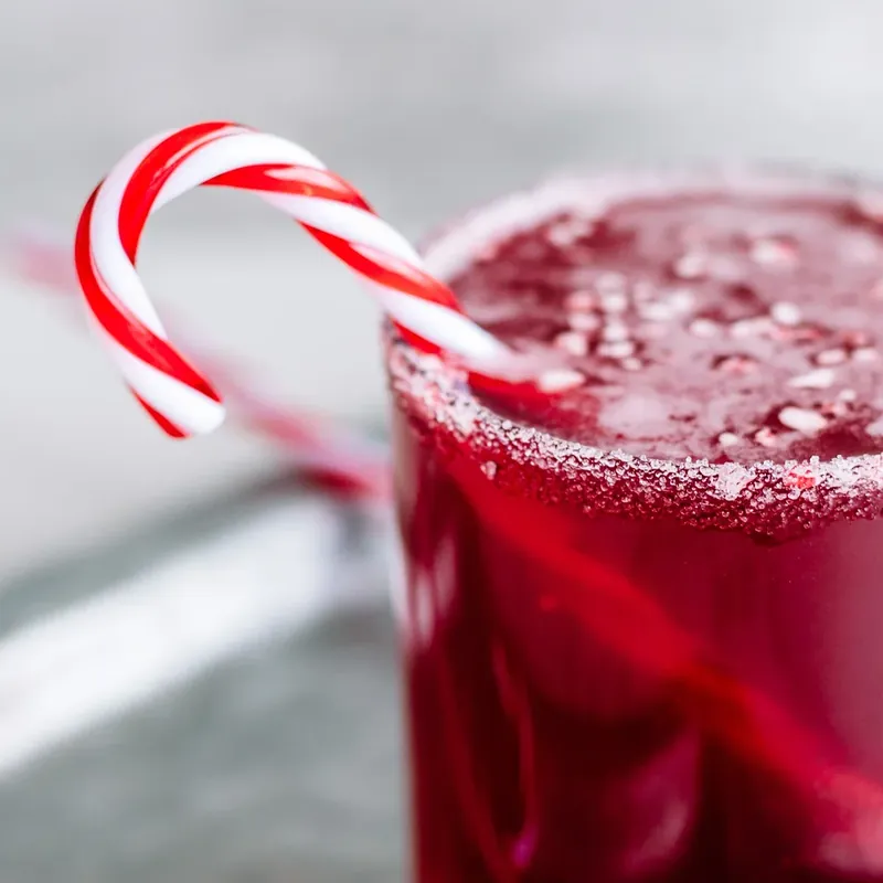 Finished candy cane margarita with crushed peppermint topping and candy cane garnish