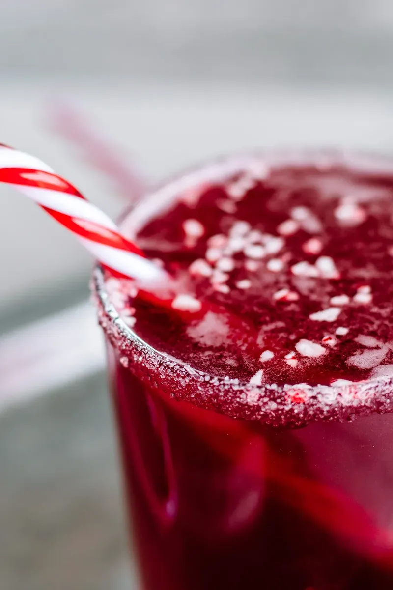Overhead view of candy cane margarita with crushed peppermint topping and candy cane straw