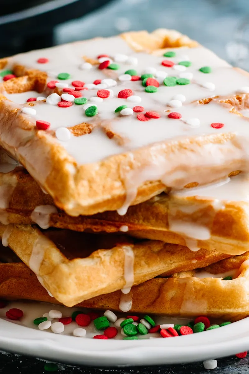 Close up view of glazed donut waffle with Christmas sprinkles showing glaze detail