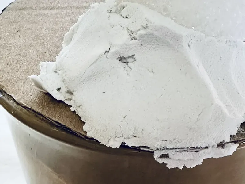 White styrofoam ball being pressed into center of cardboard circle on top of painted mug