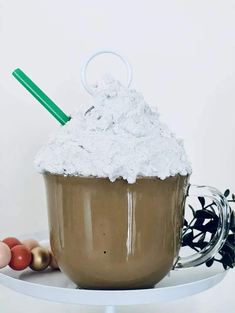 Completed Dollar Tree faux hot cocoa mug craft with brown painted interior and white spackle whipped cream topping