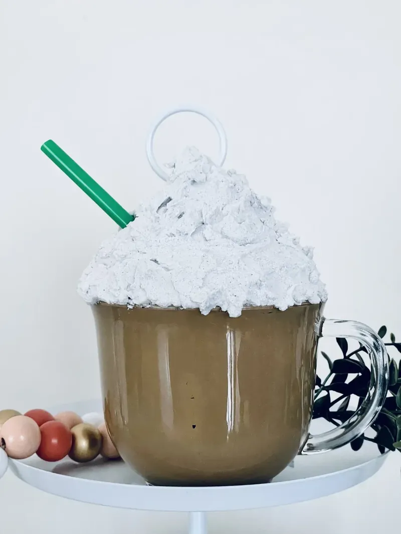 Close-up view of completed Dollar Tree faux hot cocoa mug showing realistic brown cocoa and white whipped cream texture