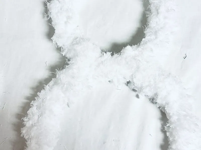 Snowman wreath form completely wrapped in fluffy white microfiber cloth