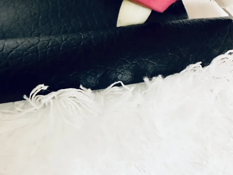 Close up of black faux leather hat detail on fluffy snowman wreath