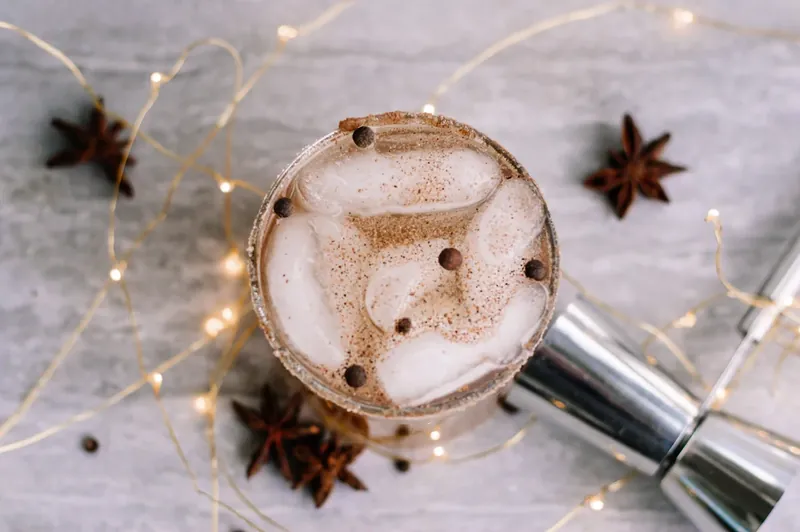 Top view of completed gingerbread margarita with nutmeg and allspice berry garnish