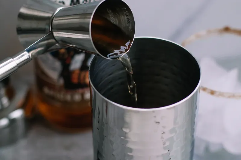 Cocktail shaker being used to mix gingerbread margarita ingredients