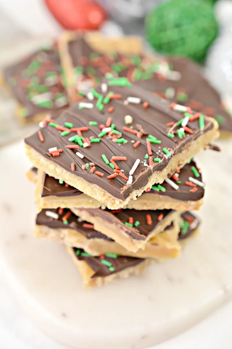 Stack of keto Christmas crack bars with chocolate and festive sprinkles