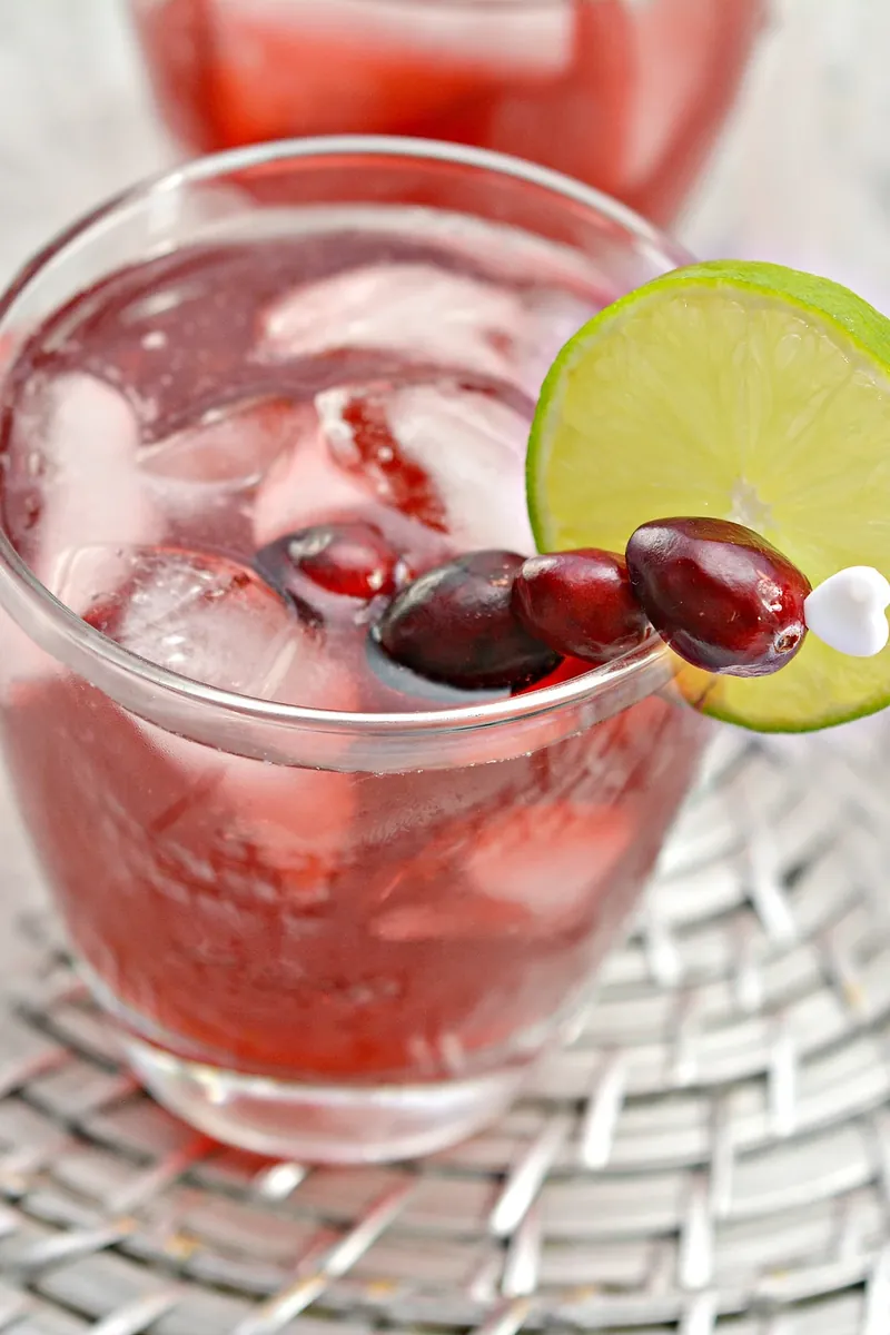 Close up of keto Christmas margarita showing cranberry and lime garnish