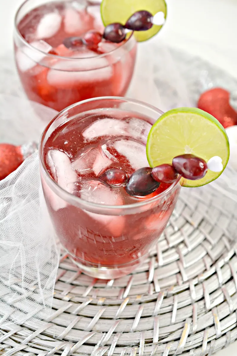 Two keto Christmas margaritas with fresh cranberries and lime slices