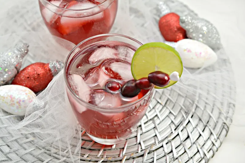 Keto Christmas margarita being served with cranberry and lime garnish