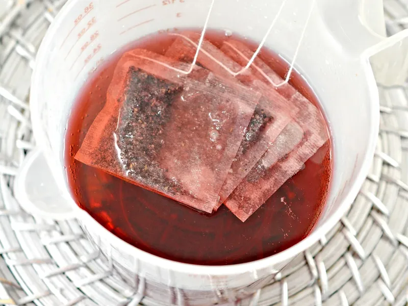 Cranberry tea bags steeping in hot water in microwave safe bowl
