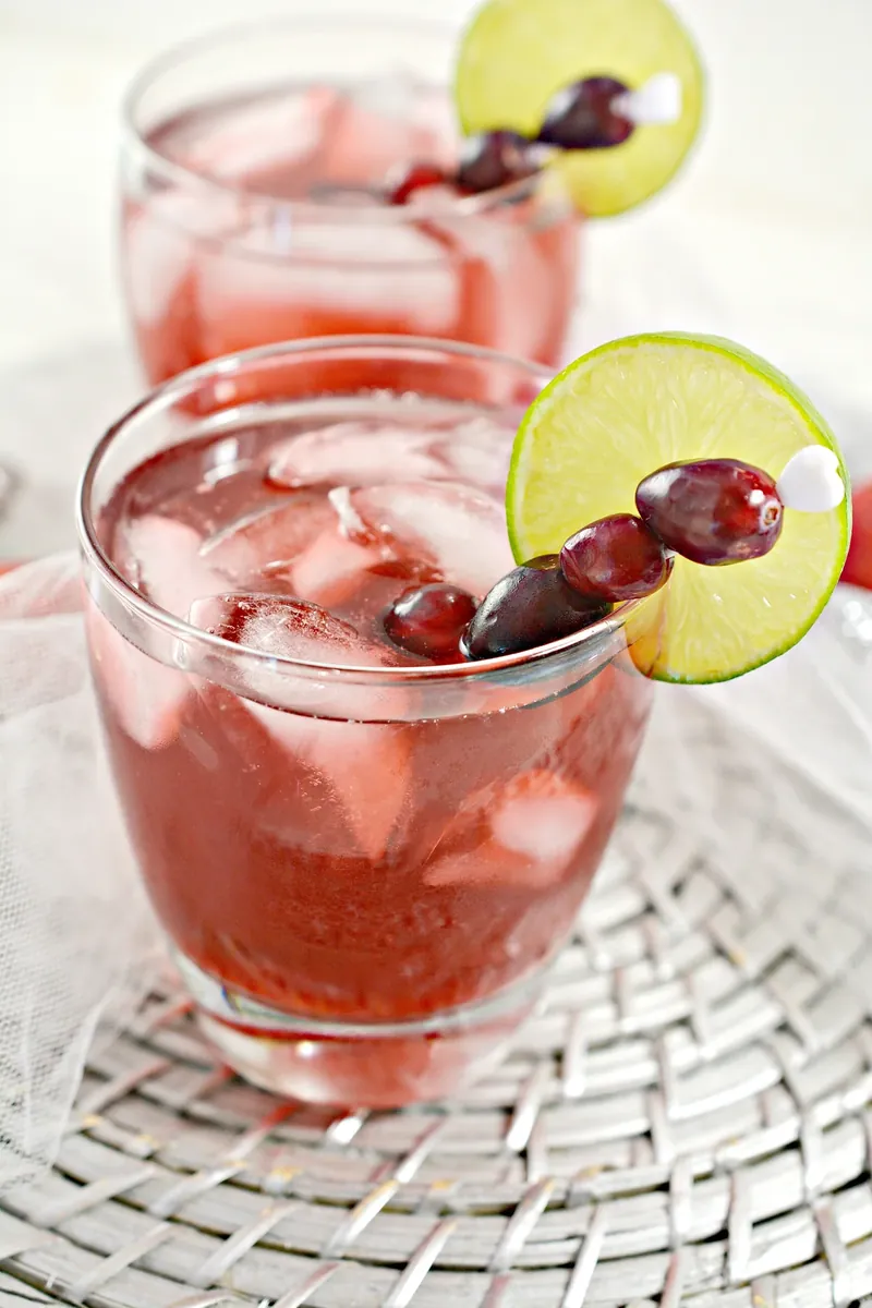 Keto Christmas margarita with cranberries and lime garnish in glass