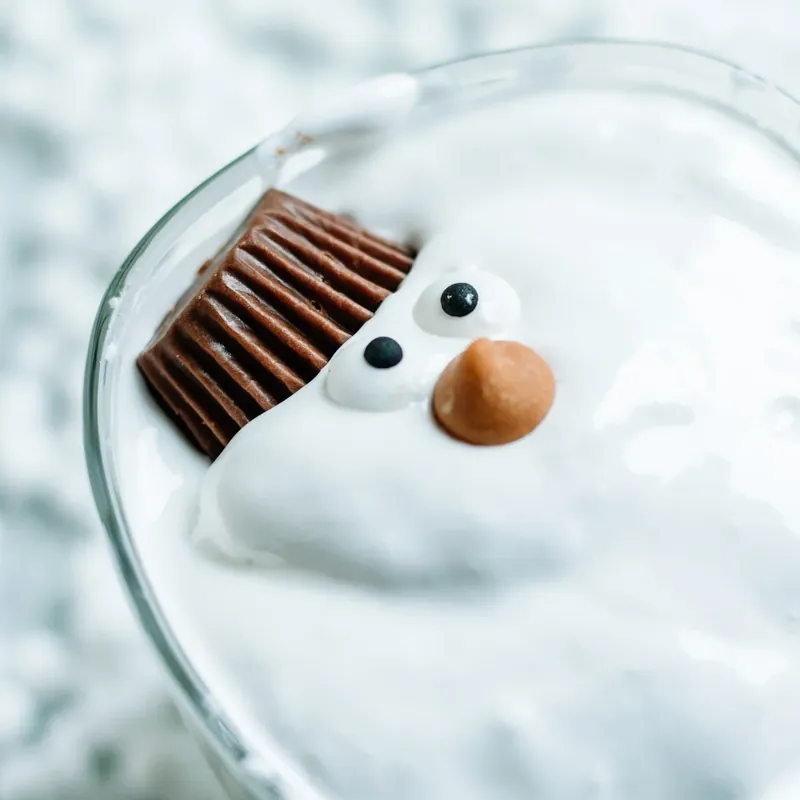Single melted snowman margarita showing detailed view of marshmallow snowman face with candy decorations