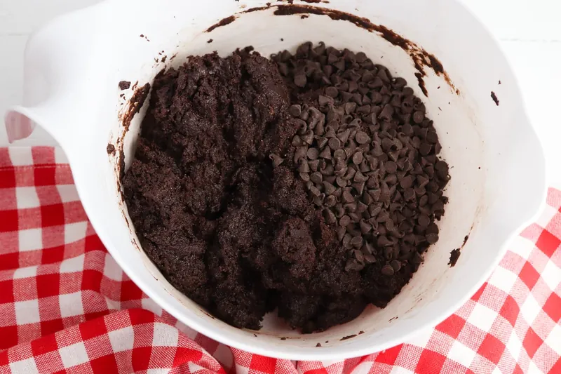 Folding mini chocolate chips into chocolate cookie dough