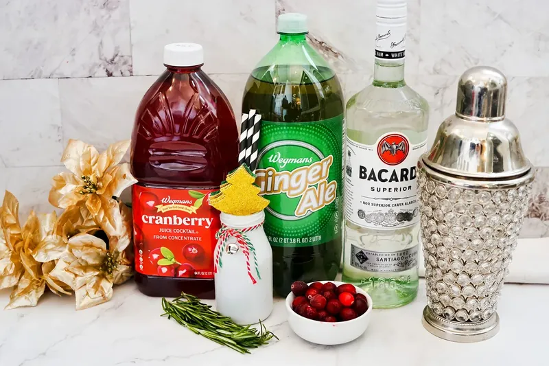 Ingredients for Reindeer Bacardi Punch including Bacardi rum, cranberry juice, ginger ale, rosemary and cranberries