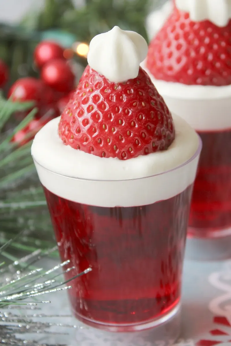 Beautiful santa hat jello shots arranged on festive table with Christmas decorations