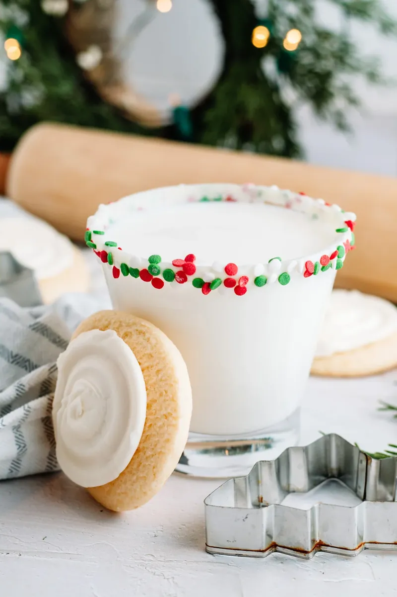Finished sugar cookie margarita with sugar cookie garnish and Christmas tree background