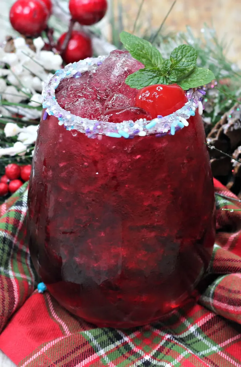 Close-up view of sugar plum cocktail with detailed view of garnish and sparkling rim