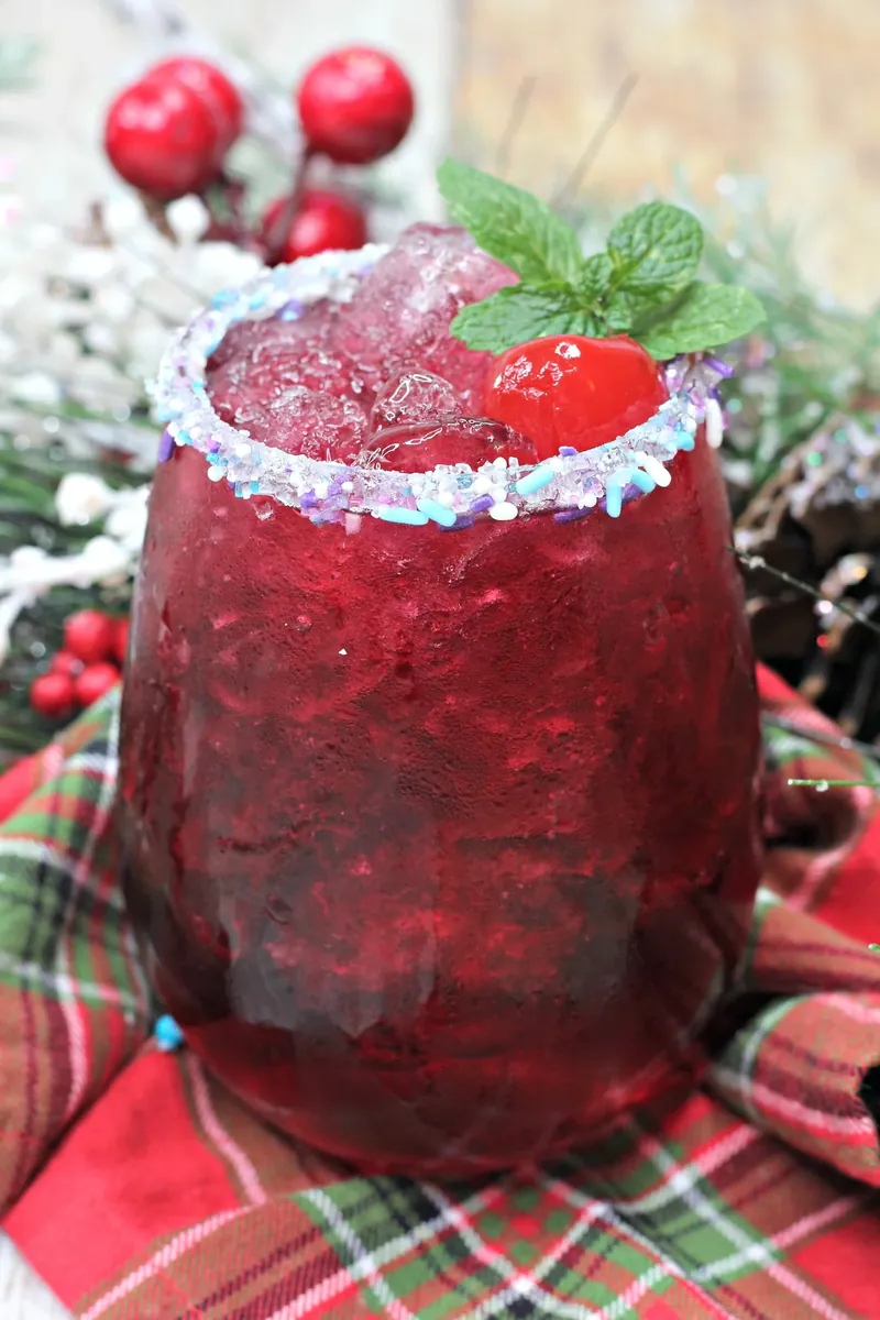 Sugar plum cocktail on festive plaid fabric with Christmas decorations