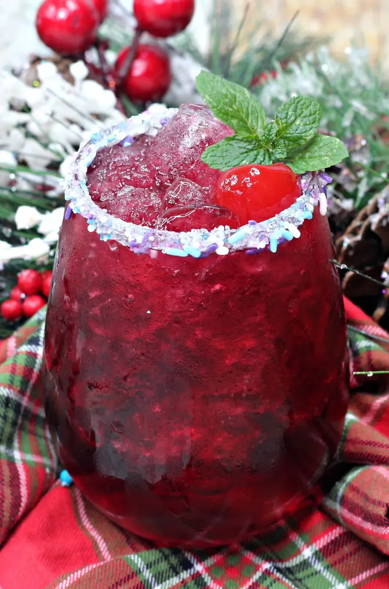 Finished sugar plum cocktail with sparkling rim and garnish in holiday setting