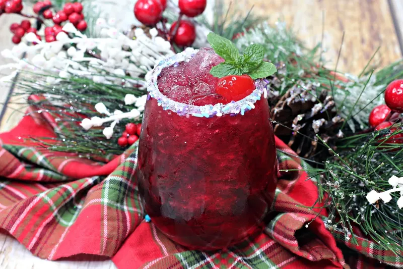 Sugar plum cocktail ingredients being mixed in cocktail shaker with ice