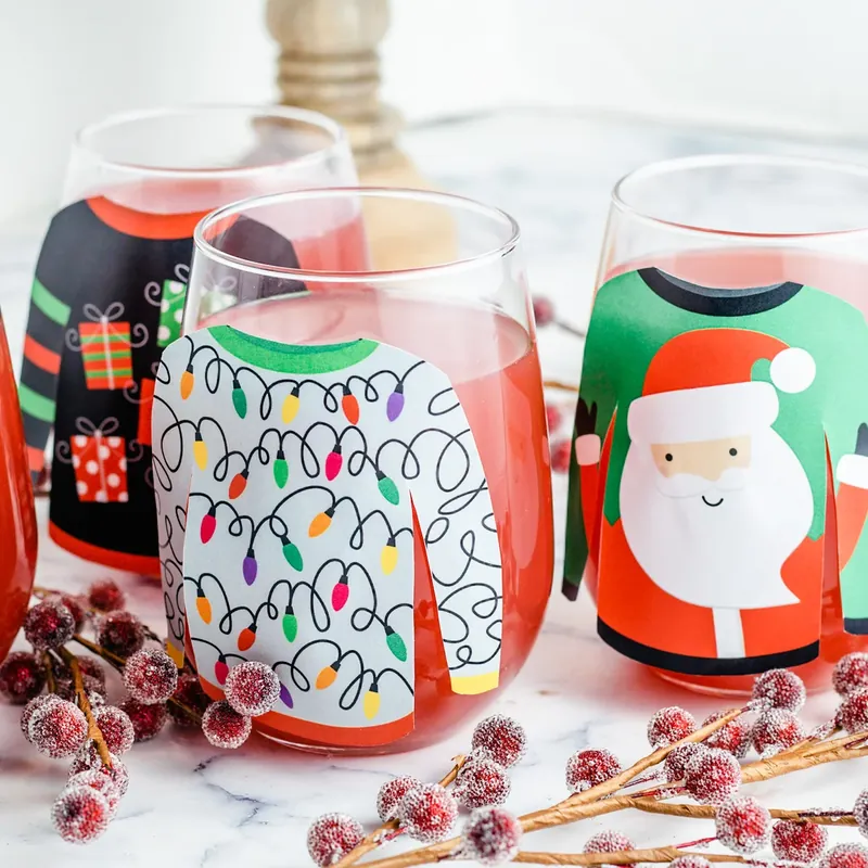 Beautiful display of Christmas sweater decorated glasses filled with pink punch