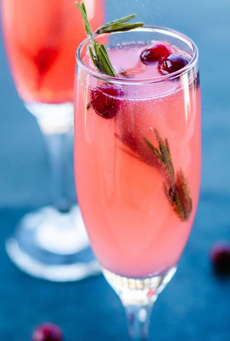 Close up of vanilla cranberry mimosa showing champagne bubbles and pink color