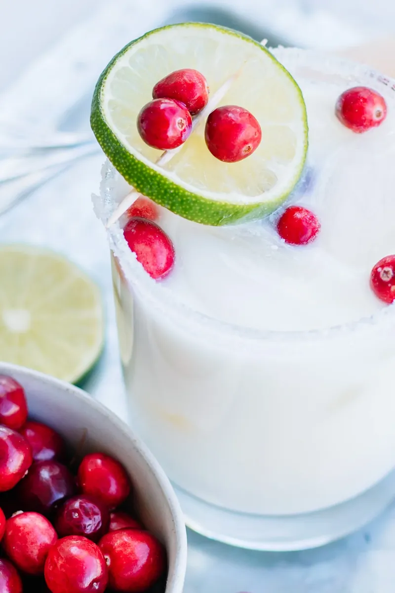 White Christmas Margarita showing creamy texture with lime wheel and cranberry garnish