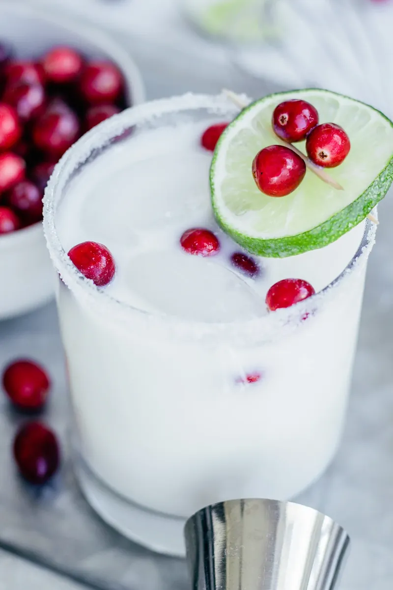 Beautiful White Christmas Margarita with cranberry garnish and peppermint rim
