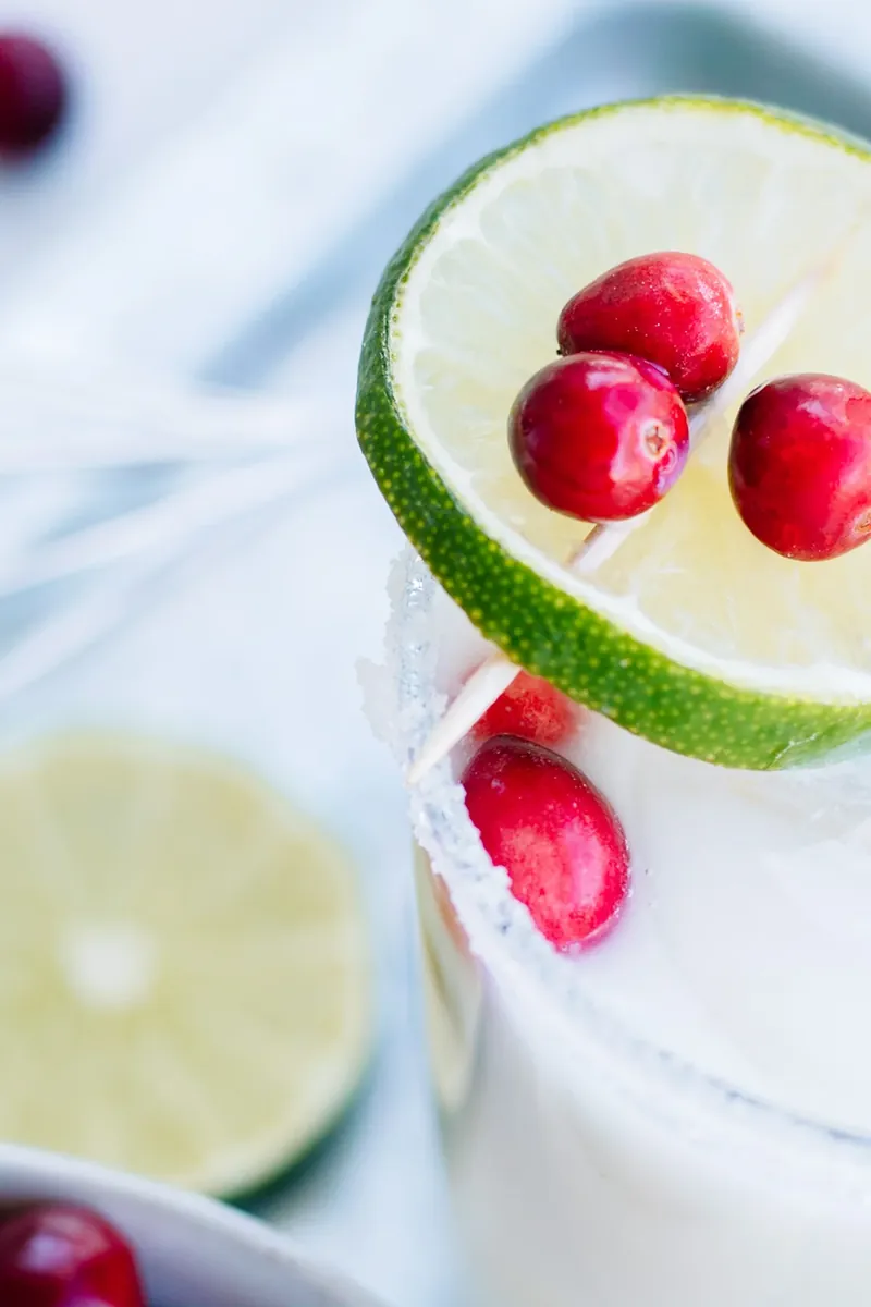 Close up detail of White Christmas Margarita with peppermint rim and fresh cranberries