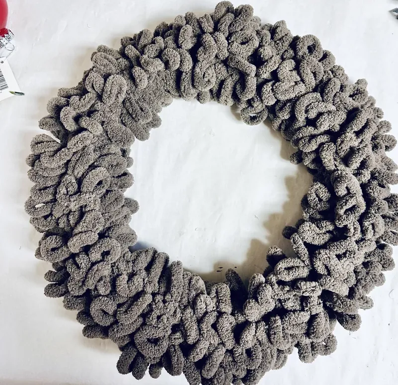 Wire wreath form completely wrapped in fluffy taupe yarn showing full coverage