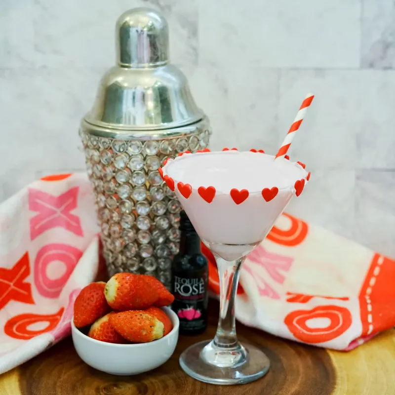 Full Valentine's chocolate strawberry martini setup with shaker, strawberries, and decorated glass