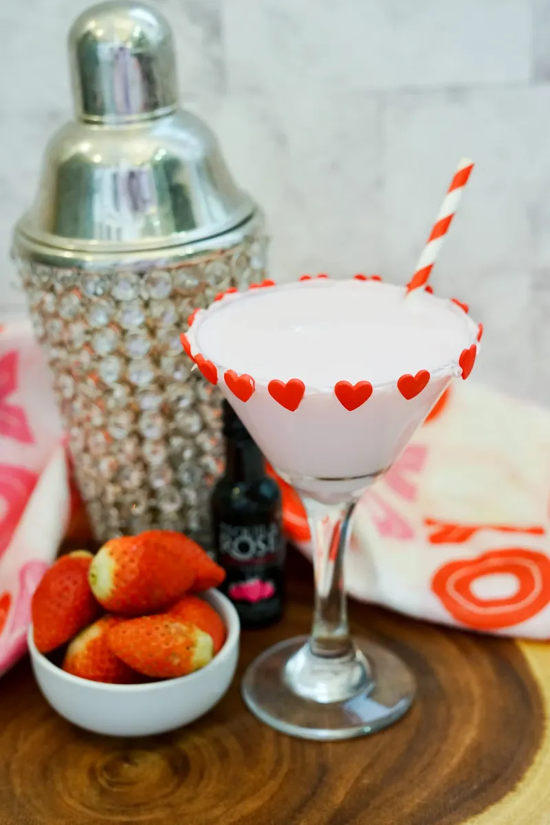 Valentine's chocolate strawberry martini with heart decorations on frosted rim and striped straw